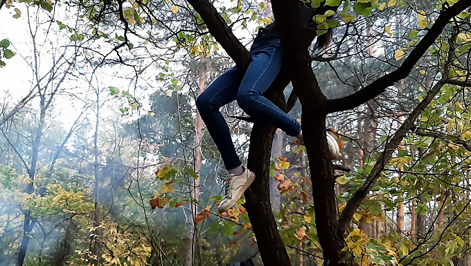 Junge Brünette Befriedigt Sich Selbst, Indem Sie In Der Öffentlichkeit Gegen Einen Baum Grinst